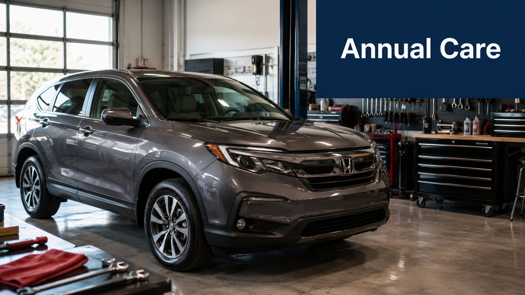 A gray Honda SUV parked inside a professional automotive repair shop for annual maintenance and rust proofing service.